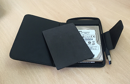 Open wallet showing drive, cable, packing and clasp.